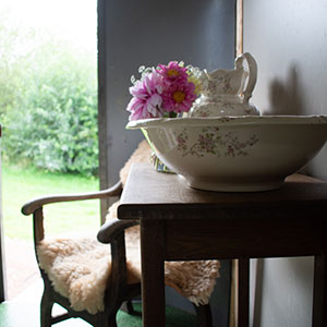 Fresh flowers and Edwardian ceramics in the Showman's Waggon at Beili Glas, Monmouthshire, Wales 